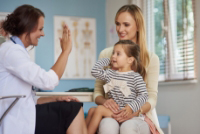 Doctor high-fiving a child during an appointment
