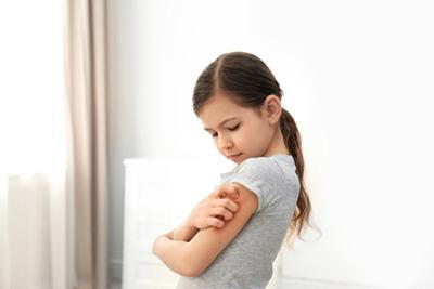 Little girl visibly uncomfortable while scratching her itchy arms