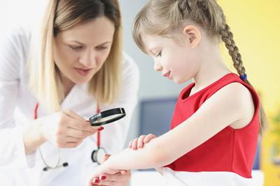 Child with hand rashes being evaluated by pediatrician